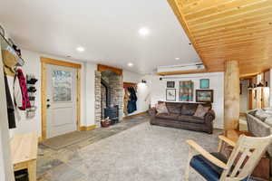 Living area with a wood stove, stone tile flooring, and recessed lighting