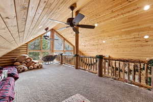 Sitting room featuring log walls, carpet, and wood ceiling