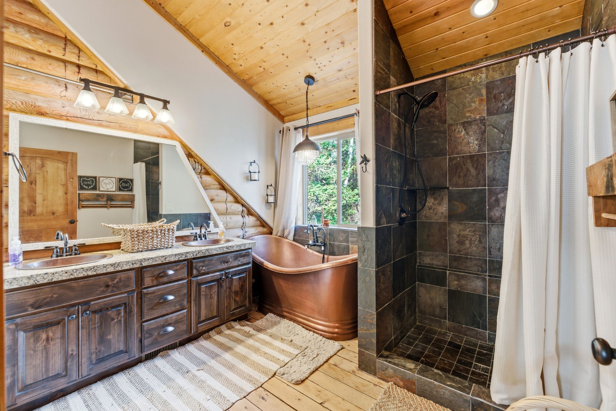 Bathroom featuring wooden ceiling, double vanity, a shower stall, light wood-style floors, and a soaking tub