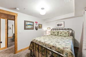Carpeted bedroom featuring baseboards and a textured ceiling