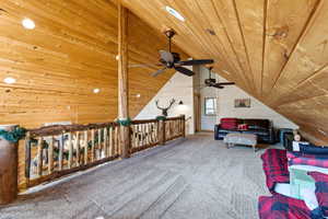 Sitting room featuring carpet floors, wooden walls, and wooden ceiling