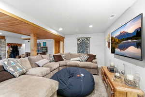 Living area featuring wooden walls, carpet flooring, and recessed lighting