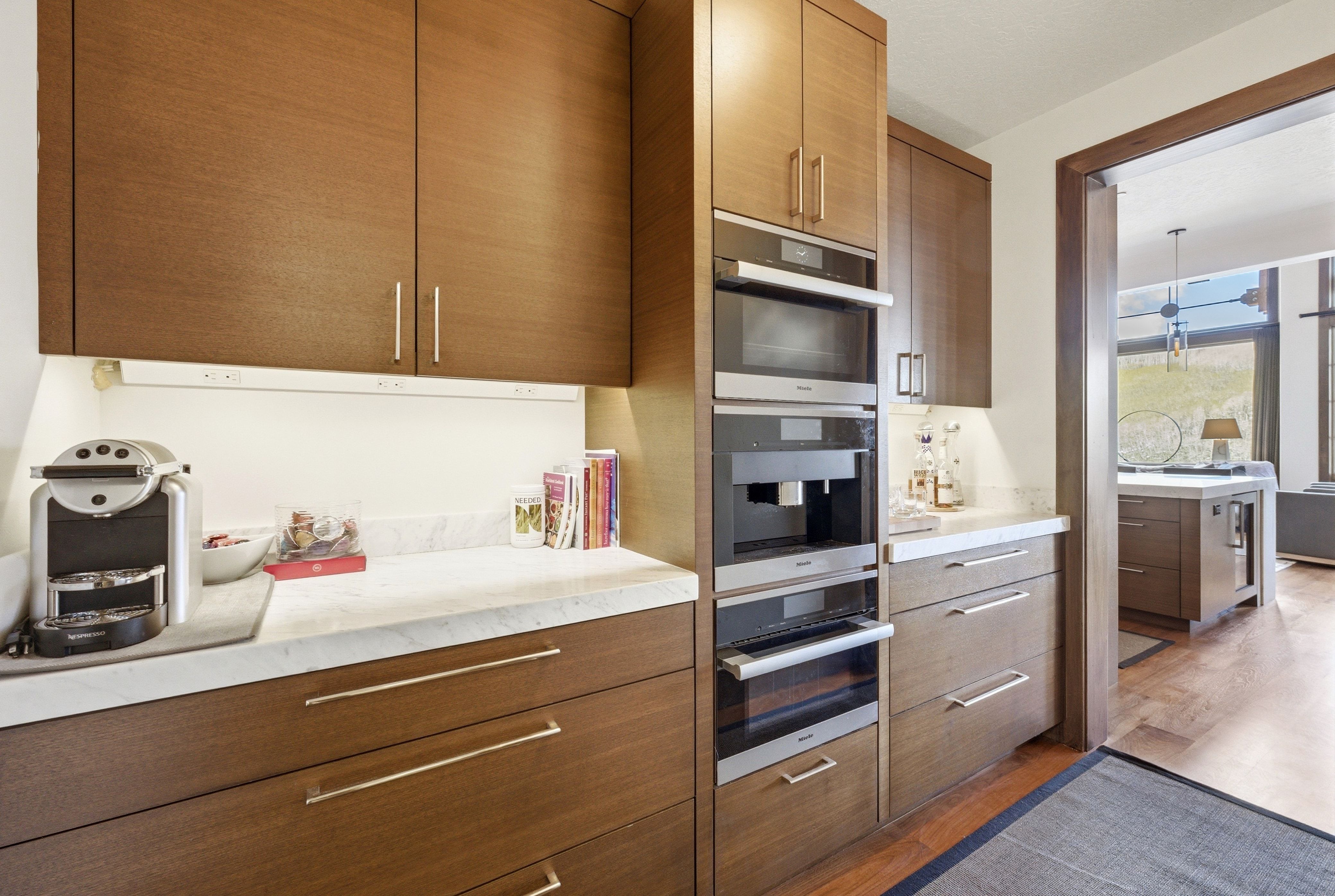 Kitchen featuring dark wood-style flooring, modern cabinets, oven, and wood finish cabinets