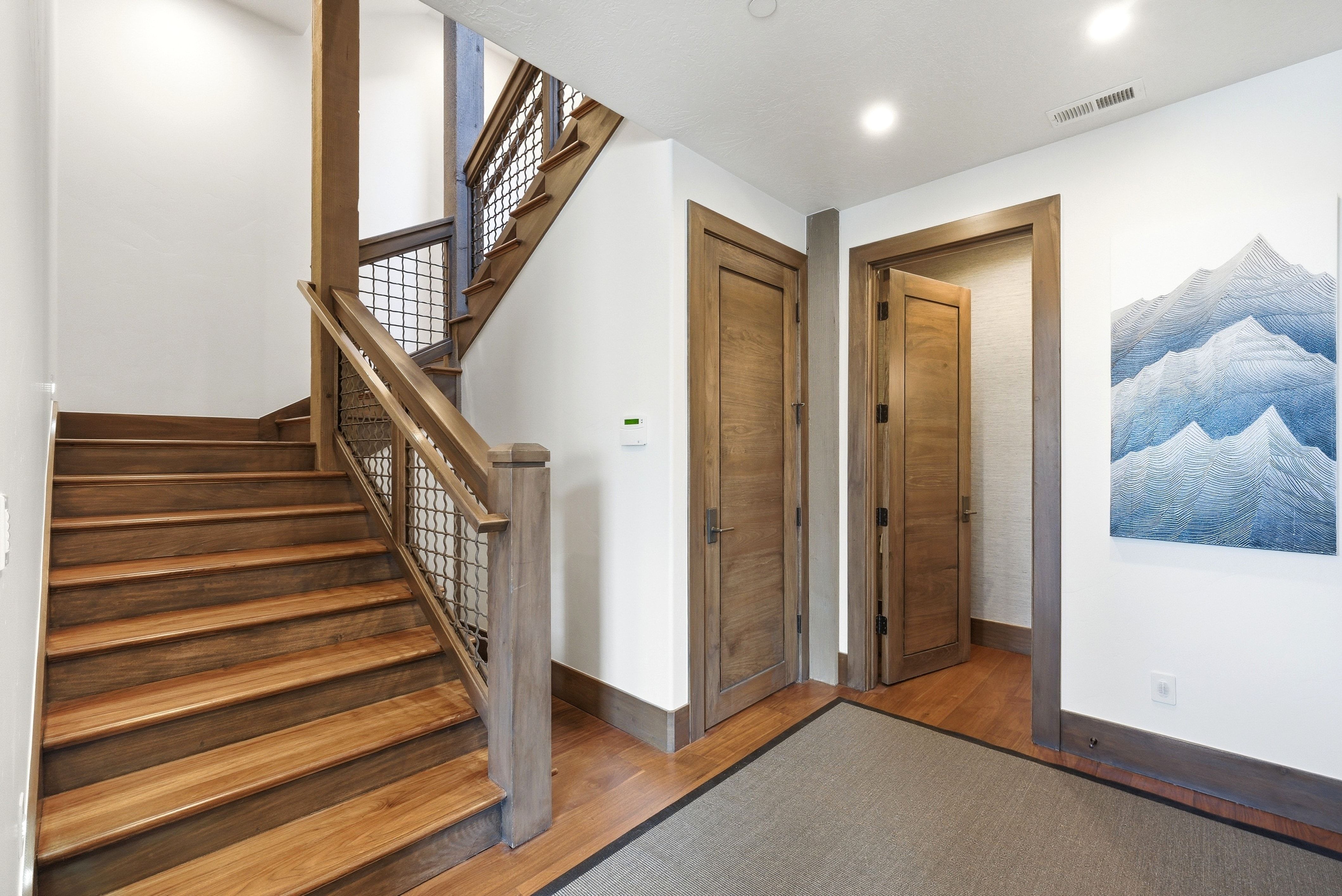 Stairs with hardwood / wood-style flooring and baseboards