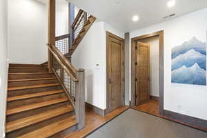 Stairs with hardwood / wood-style flooring and baseboards