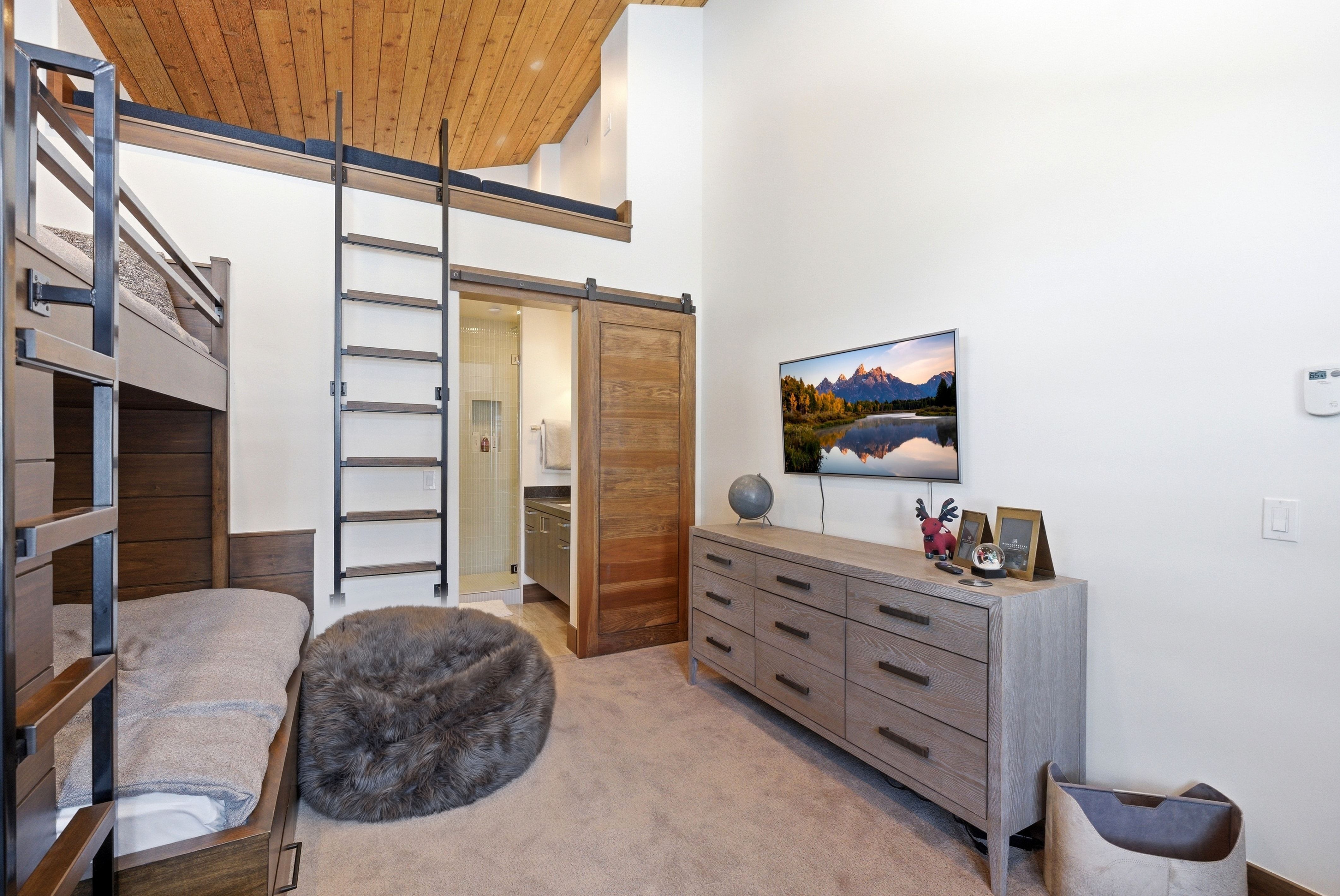Sitting room featuring a barn door, a high wood ceiling, and light carpet