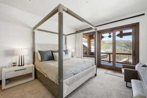 Bedroom with access to exterior and light colored carpet