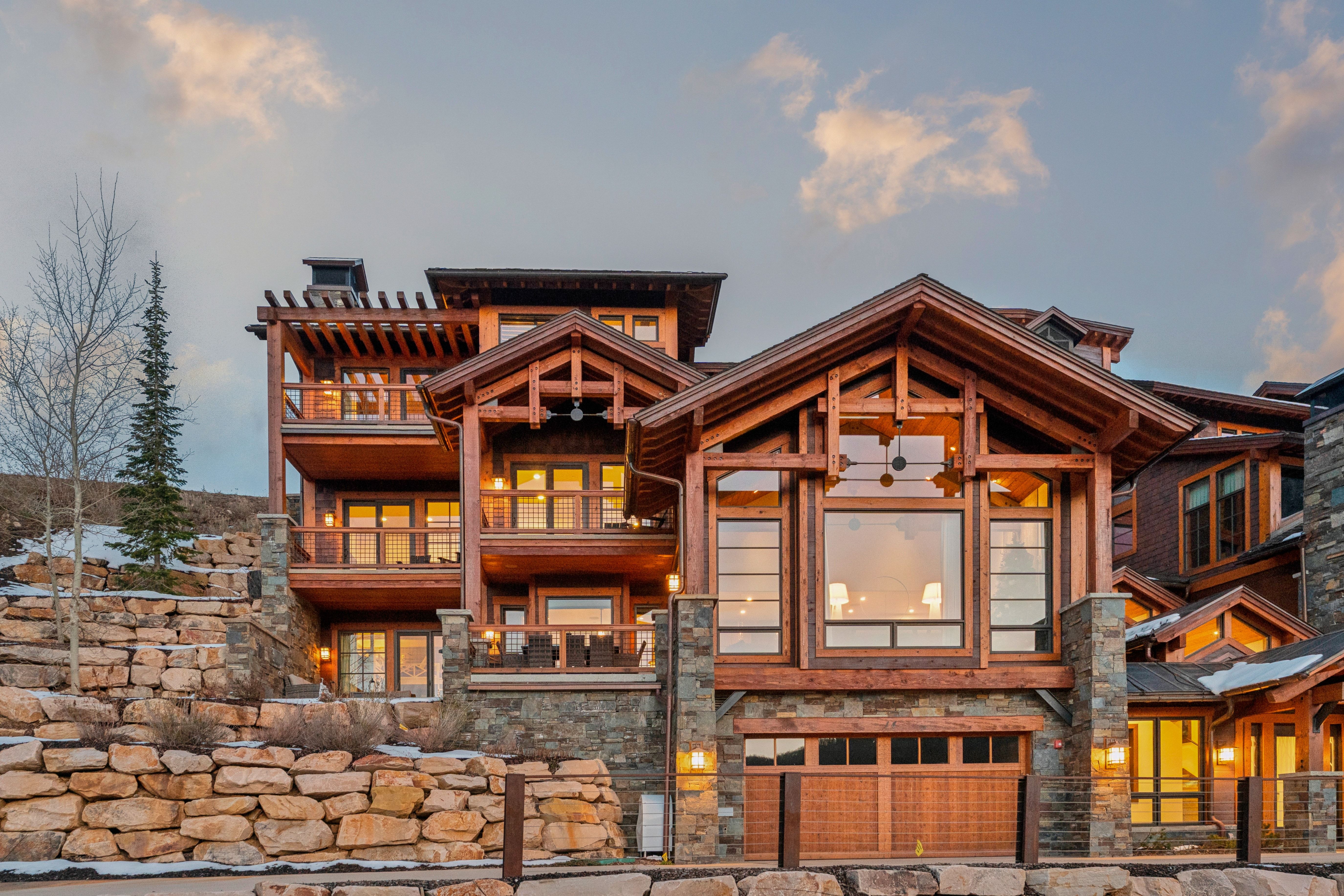 Back of property with a balcony and stone siding