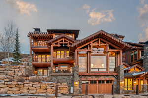Back of property with a balcony and stone siding