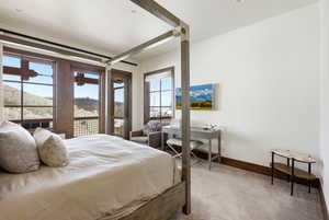 Bedroom with light carpet, access to outside, and a mountain view