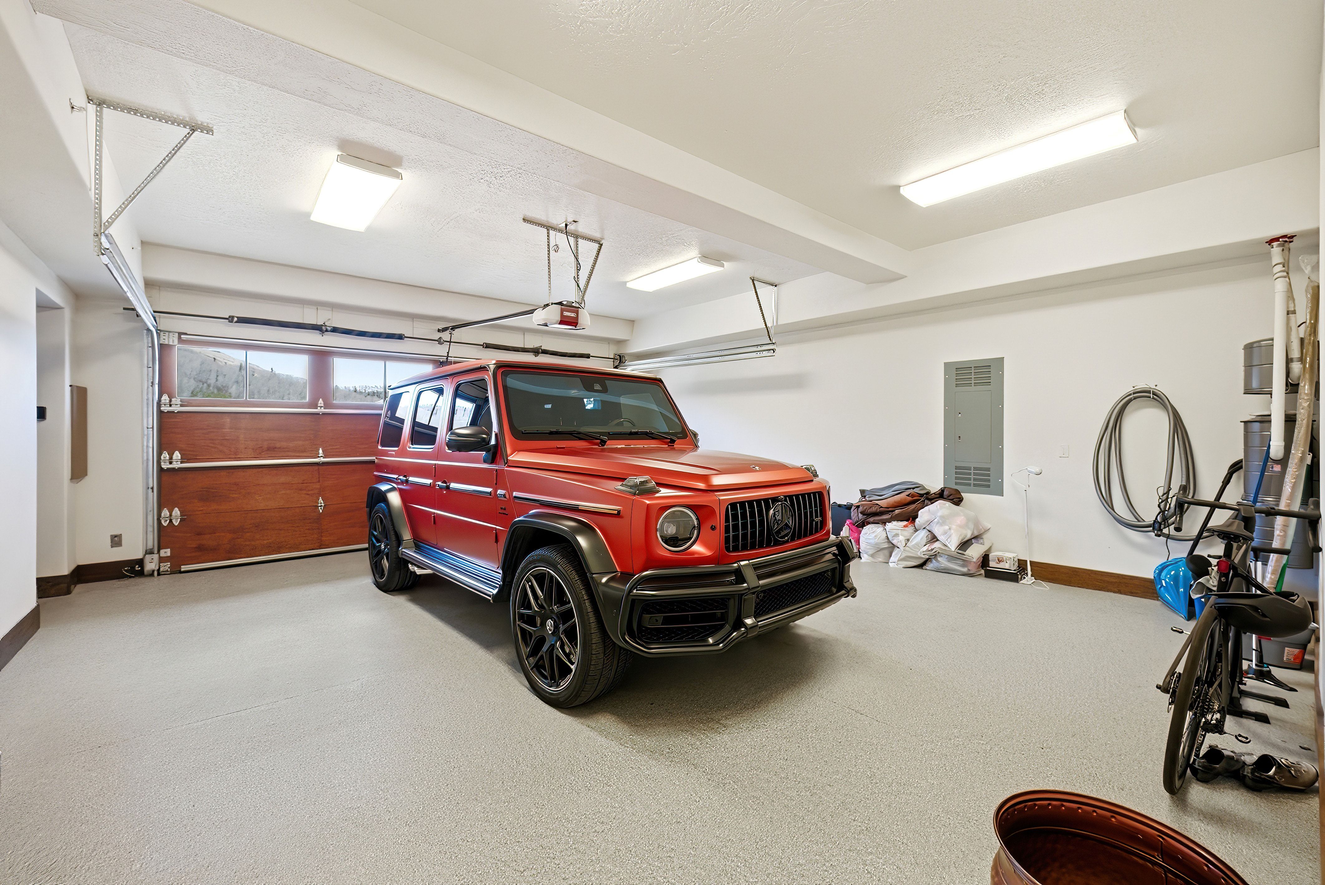 Garage featuring baseboards and electric panel