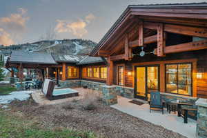 Back of house featuring a patio area, stone siding, and a mountain view
