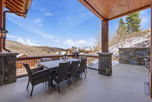 Snow covered patio featuring outdoor dining area and a mountain view