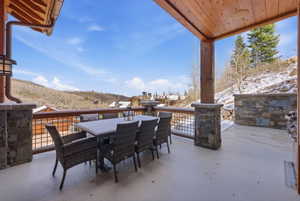 Snow covered patio featuring outdoor dining area and a mountain view