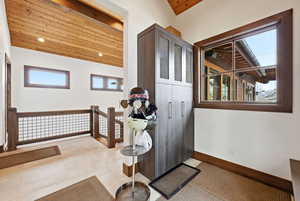 Doorway to outside with wood ceiling and tile patterned flooring