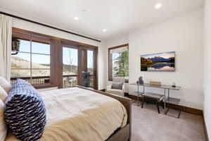 Bedroom with light carpet, recessed lighting, a mountain view, and access to outside