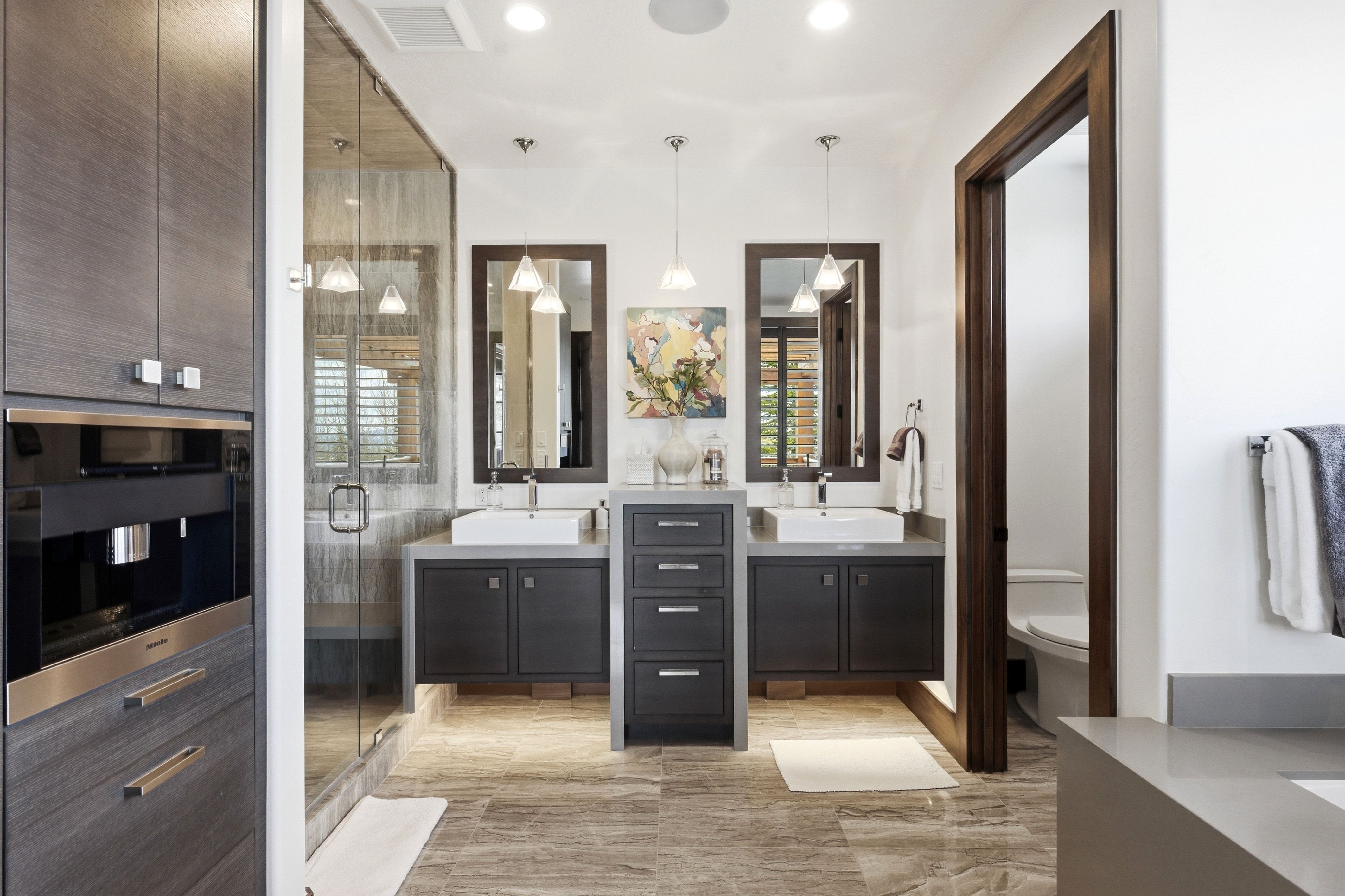 Full bathroom featuring two vanities and a shower stall