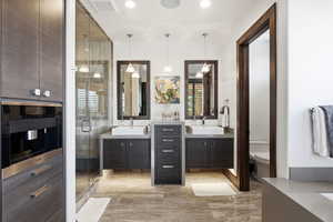 Full bathroom featuring two vanities and a shower stall