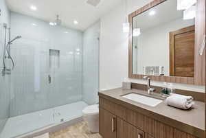 Full bath with vanity, a shower stall, and recessed lighting