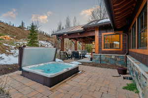 View of patio with outdoor dining space and an outdoor hot tub