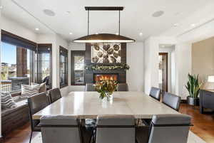 Dining space featuring wood finished floors, a fireplace, and recessed lighting