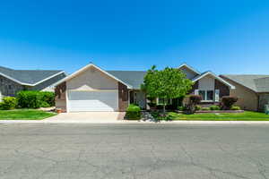 Ranch-style home featuring brick siding, a garage, driveway, and a shingled roof