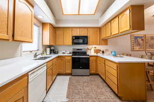 Kitchen featuring a peninsula, a breakfast bar area, stainless steel electric stove, dishwasher, and black microwave