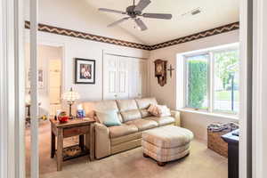 Living area with carpet floors, lofted ceiling, and a ceiling fan