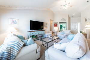 Living room with ceiling fan and lofted ceiling