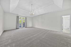 Bedroom with light carpet and chandelier