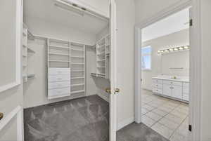 Walk in closet featuring light carpet and light tile floors