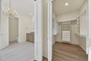 Walk in closet with chandelier in primary suite bathroom
