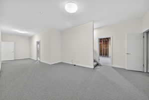Unfurnished room featuring carpet floors and baseboards