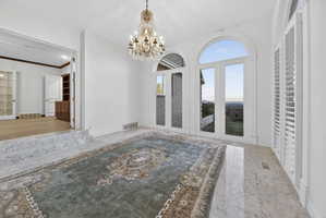 Solarium featuring a chandelier and ornamental molding