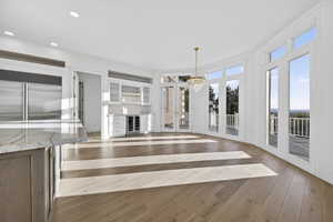 Kitchen with wine nook, breakfast nook, hardwood floors, beverage cooler, and recessed lighting