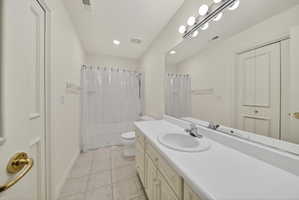 Full bath with vanity, light tile flooring, recessed lighting, and shower / tub combo