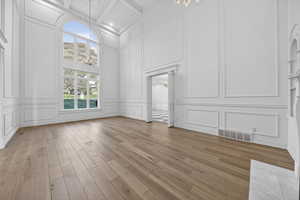 Parlor featuring a decorative wall, chandeliers, and hardwood flooring