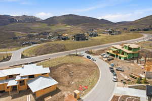 Aerial view of property and surrounding area featuring a mountain backdrop and nearby suburban area