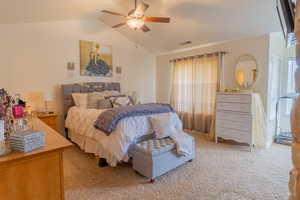 Bedroom with vaulted ceiling, ceiling fan, and light colored carpet