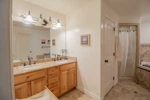 Bathroom featuring double vanity, a relaxing tiled tub, and a tile shower
