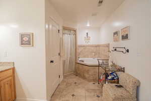 Full bathroom with a bath, vanity, and a stall shower