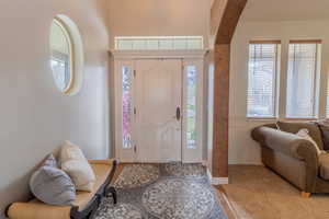 Entrance foyer with arched walkways and healthy amount of natural light