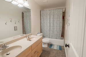 Full bath featuring double vanity and shower / bathtub combination with curtain