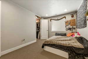 Bedroom 4 with light colored carpet, a textured ceiling, a spacious closet, and recessed lighting