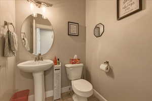 Half bathroom featuring toilet and baseboards