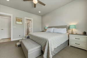 Primary bedroom featuring light carpet, ensuite bathroom, ceiling fan, and recessed lighting