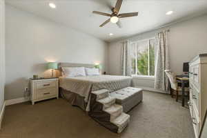Primary bedroom with dark carpet, recessed lighting, a ceiling fan, and a desk