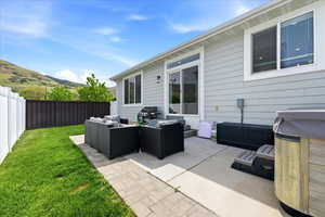 Fenced backyard with an outdoor living space, a patio area, and a mountain view