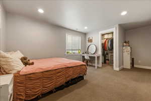 Bedroom 3 with a walk in closet, light carpet, and recessed lighting