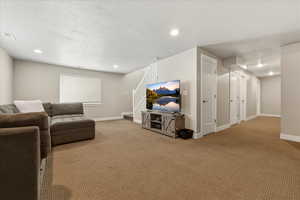 Living room with light colored carpet, recessed lighting, and a textured ceiling